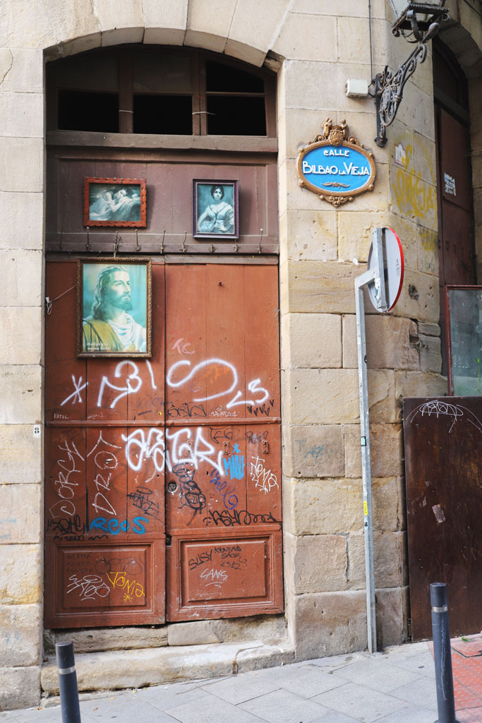 Framed portraits of Jesus and other individuals above a doorway